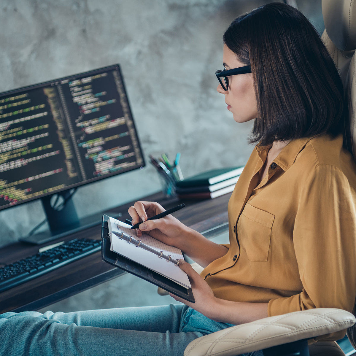 An IT programmer working from home is researching and programming on the computer